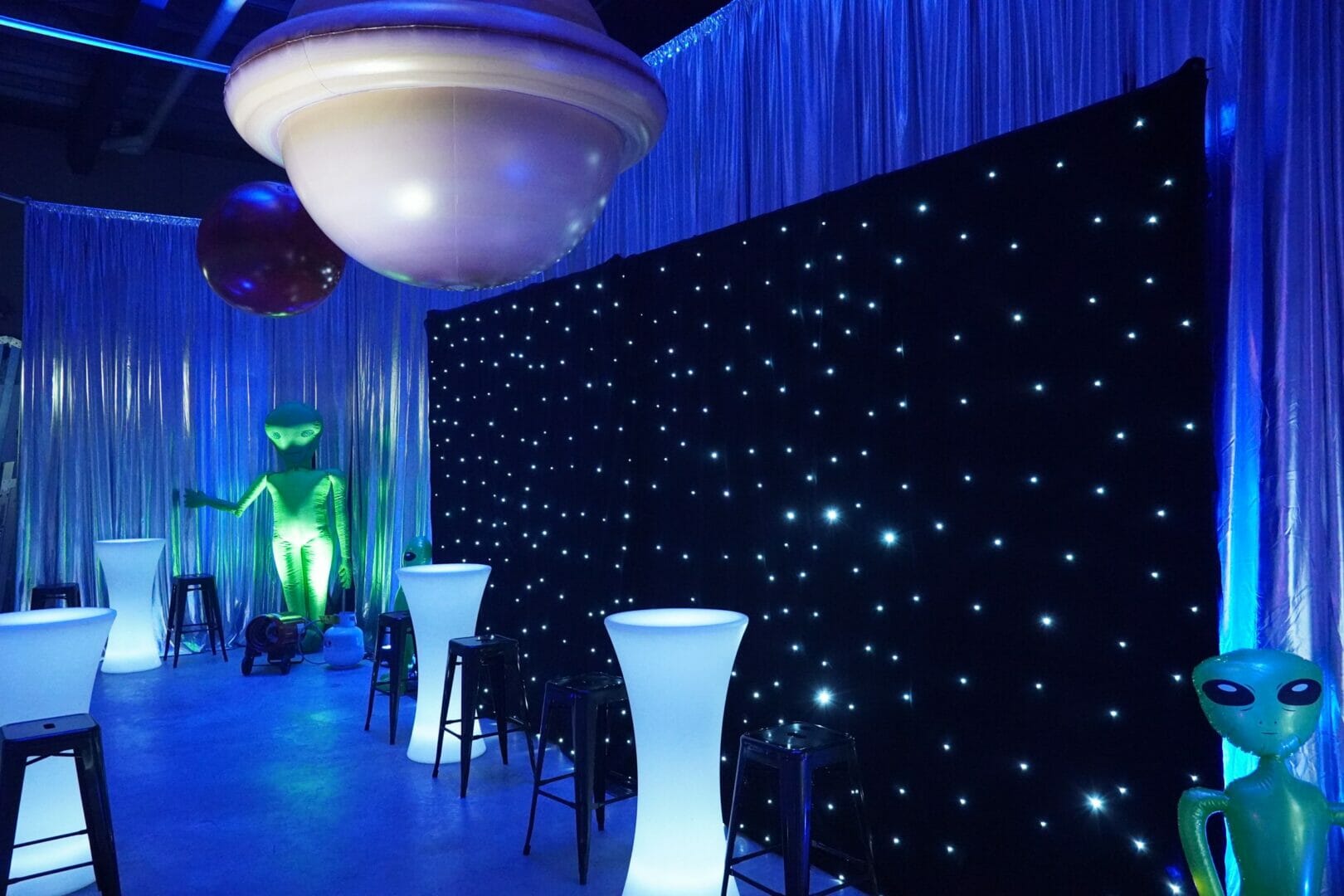 star cloth, illuminated furniture and inflatable planet at space themed party