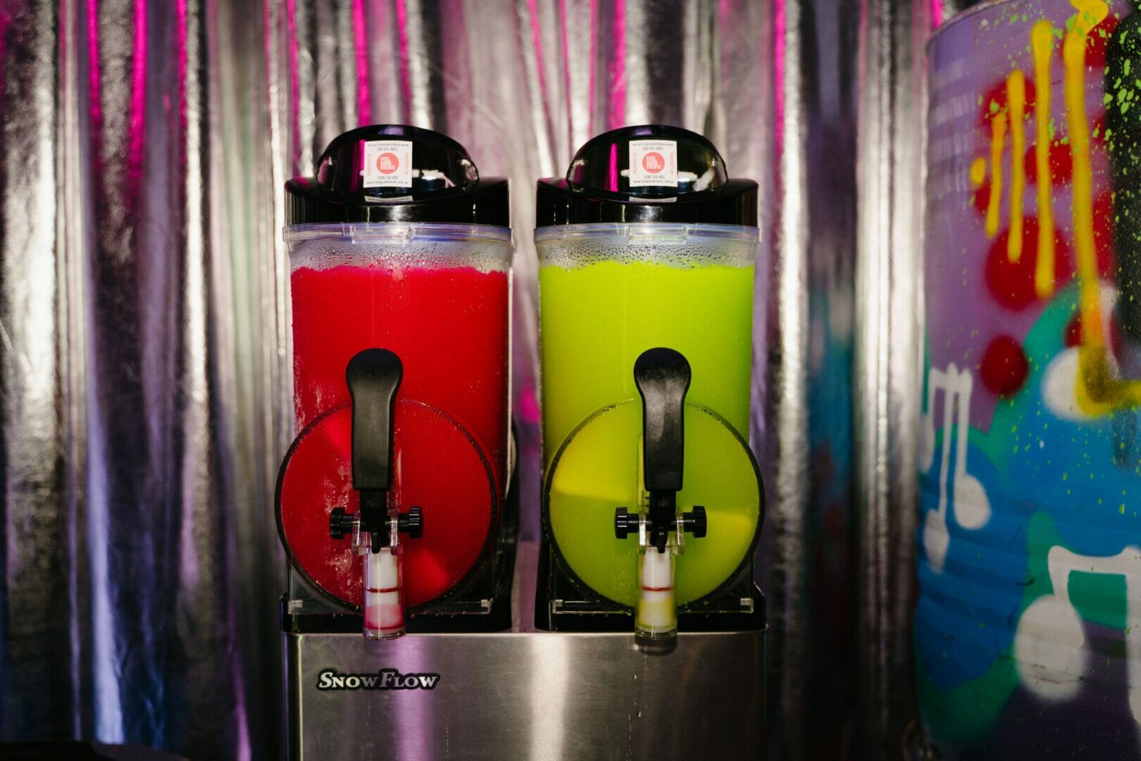 cocktail machine with frozen red and green cocktails at a party