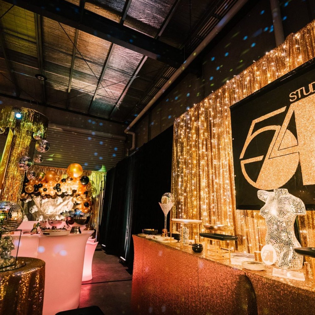 glamorous gold studio 54 themed party with themed props and gold draping