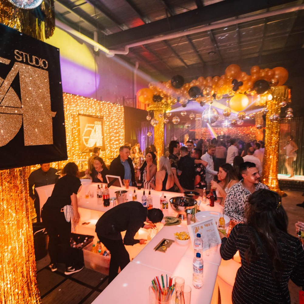 Studio 54 themed party with themed props and illuminated bar