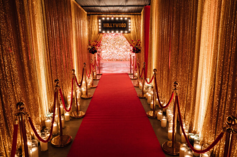 Hollywood themed entranceway with drape, red carpet, bollards, candles, and hollywood sign
