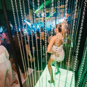 girl dancing on a podium crystal beaded curtains at studio 54 themed party
