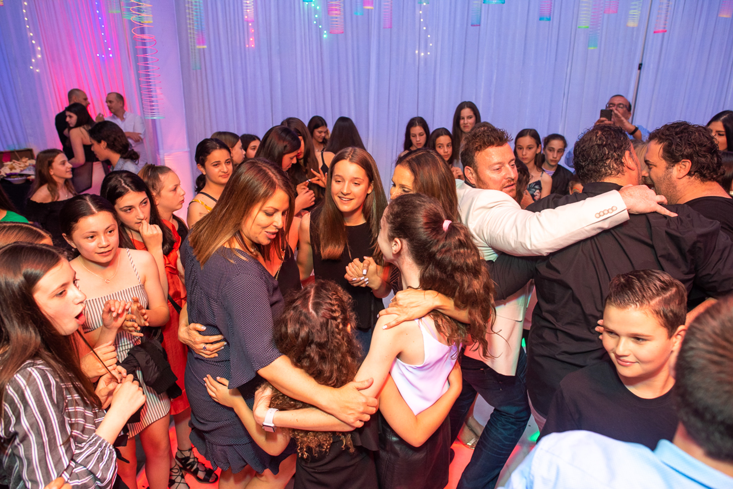full dance floor with white draping in background during bat mitzvah