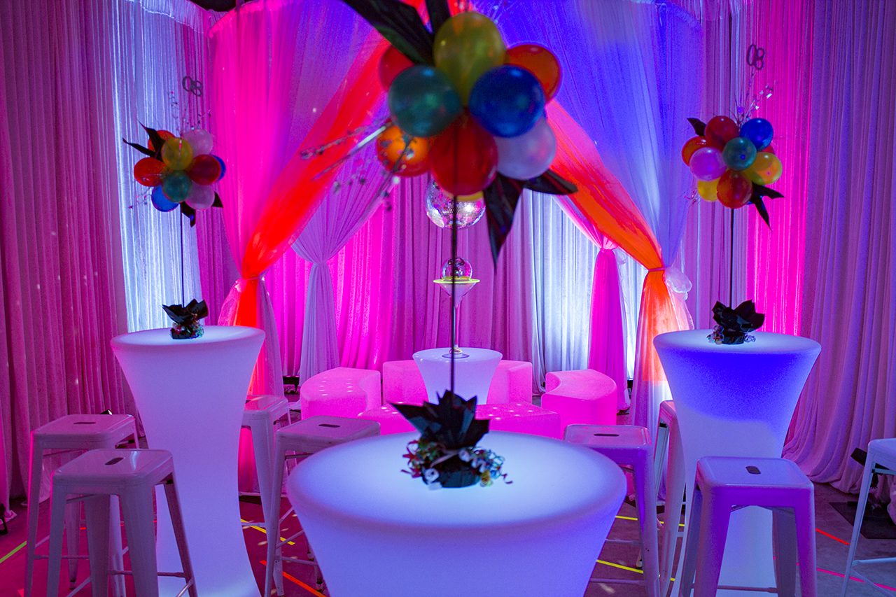 80s themed table centrepieces, illuminated furniture and draping