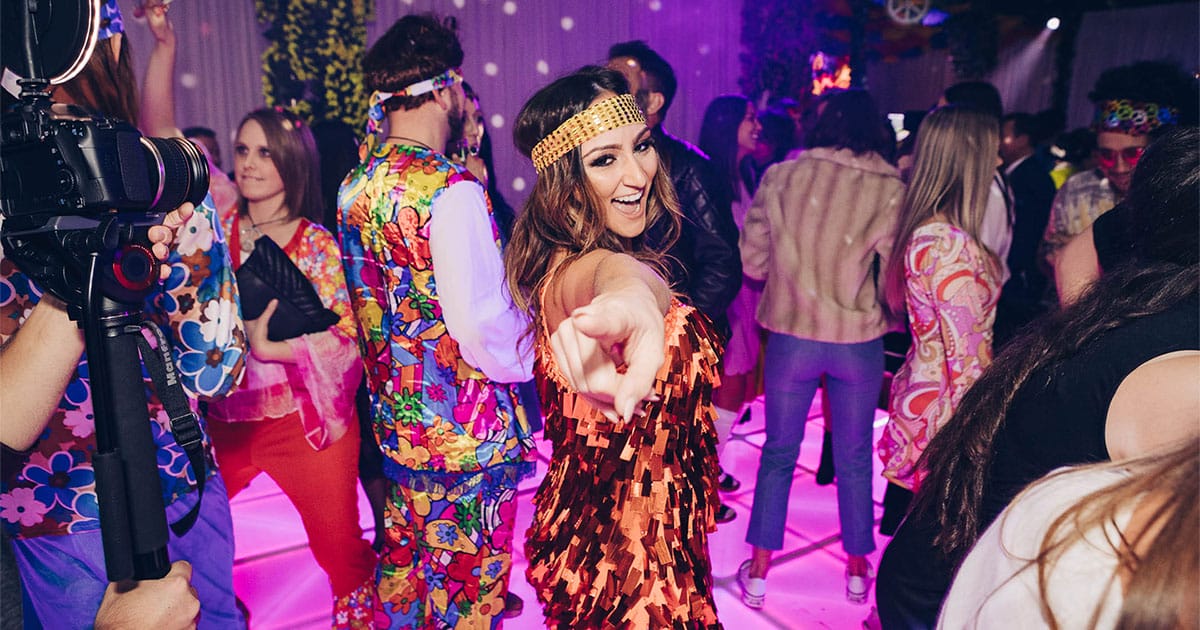 girl in a 60s themed costume dancing at a 60s themed party