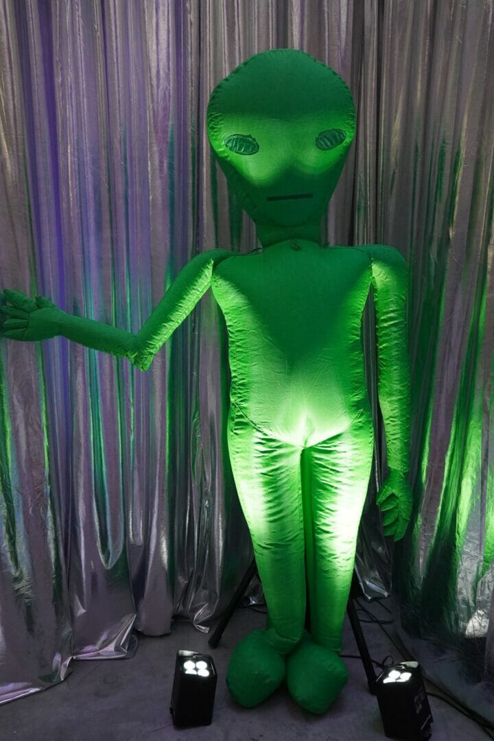 Inflatable green alien at space themed party