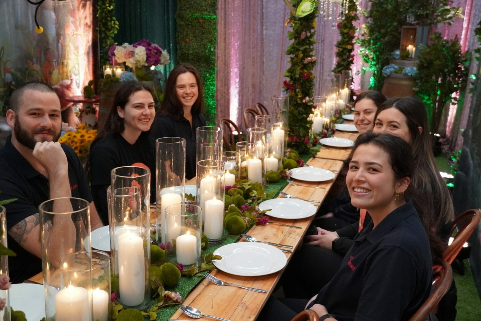 Feel good events team members sitting at an enchanted garden themed party setup.