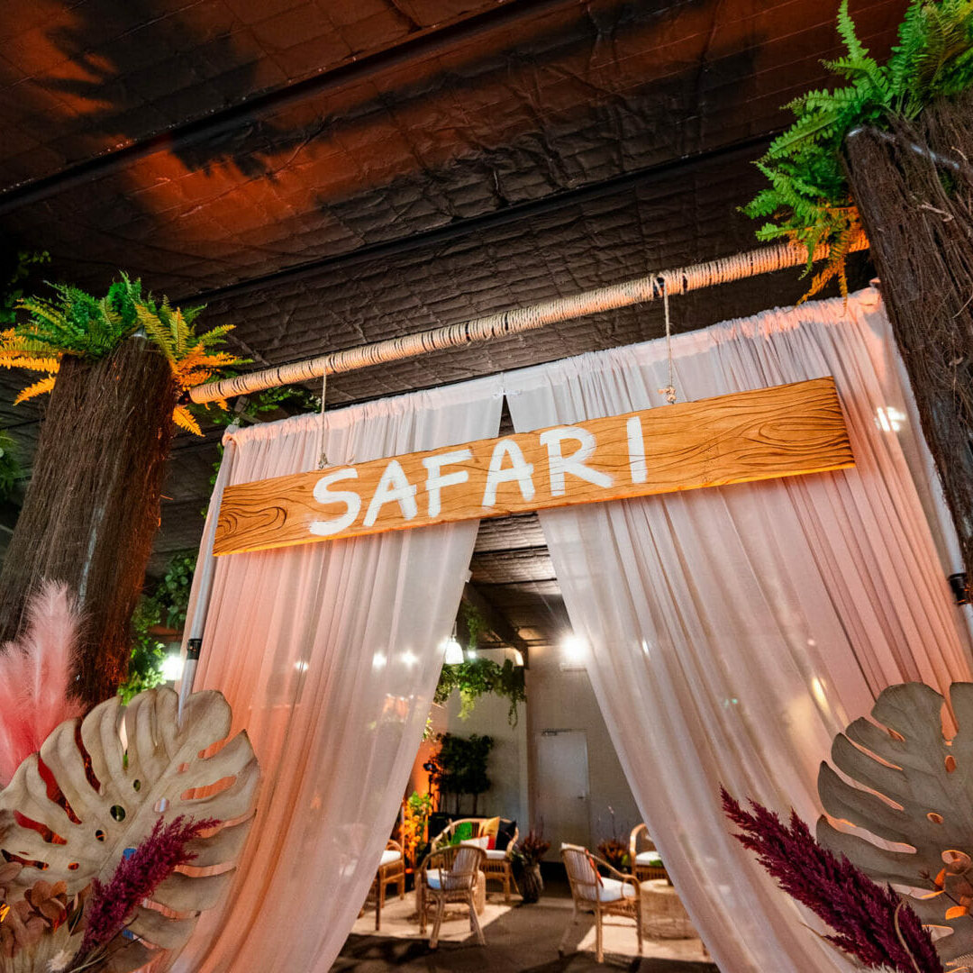 Safari themed entrance way with wooden sign and chiffon draping
