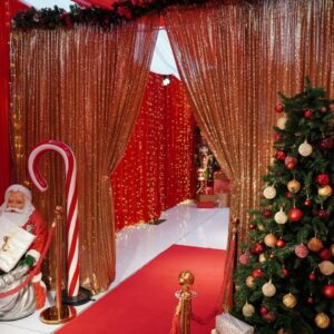 candy cane prop in christmas themed setup featuring draping, a christmas tree, and a santa prop