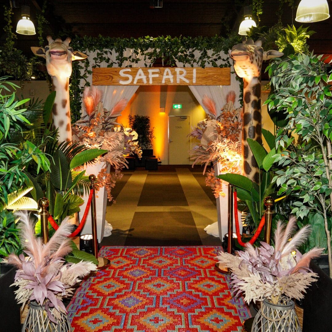 Safari themed entranceway featuring greenery, Giraffe props, dried florals, rug