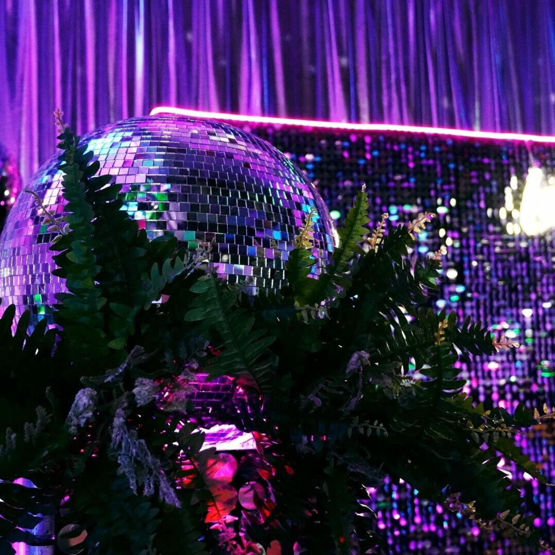 mirror balls, greenery, sequin panels, neon lights, neon sign at neon disco party theme