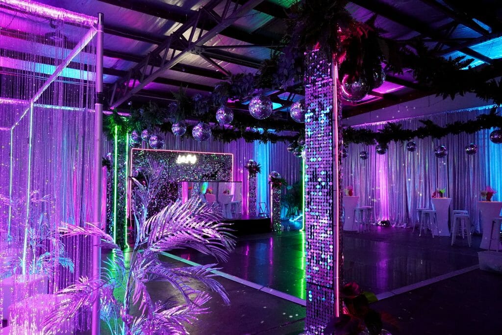 dance floor, mirror ball, sequin panels, greenery at neon disco themed party