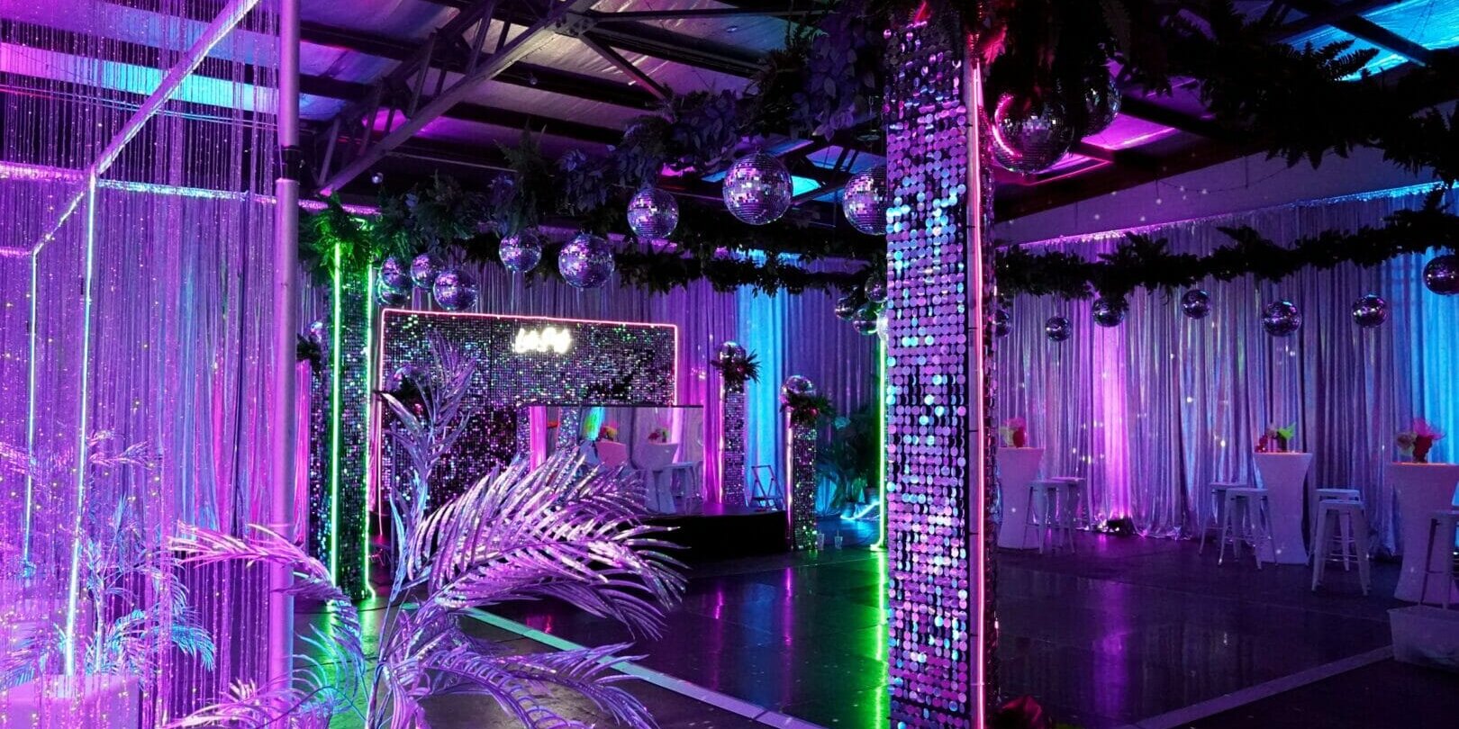 dance floor, mirror ball, sequin panels, greenery at neon disco themed party