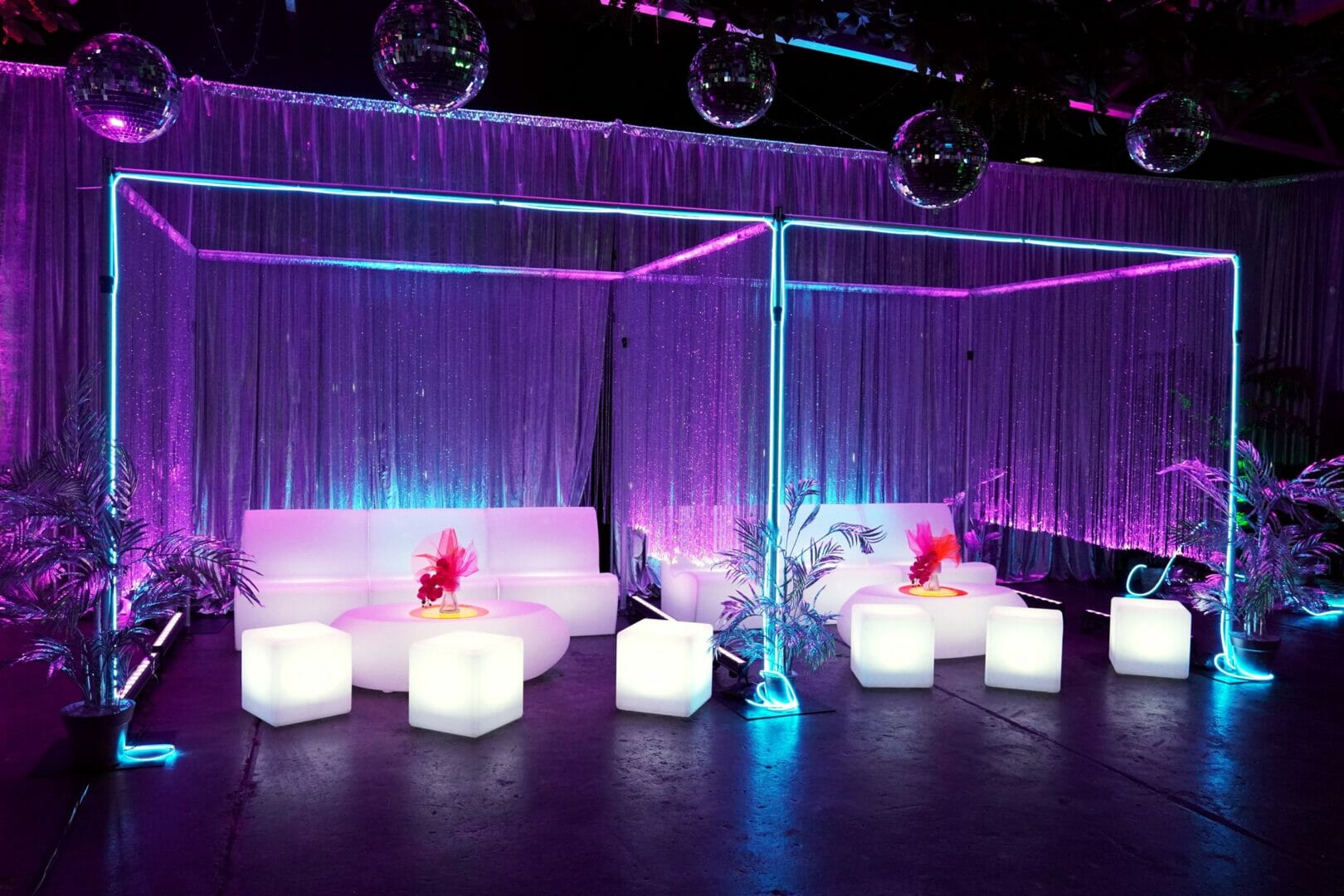 illuminated sofas, cubes, and coffee tables with beaded curtains, silver drape, neon lights and mirror balls