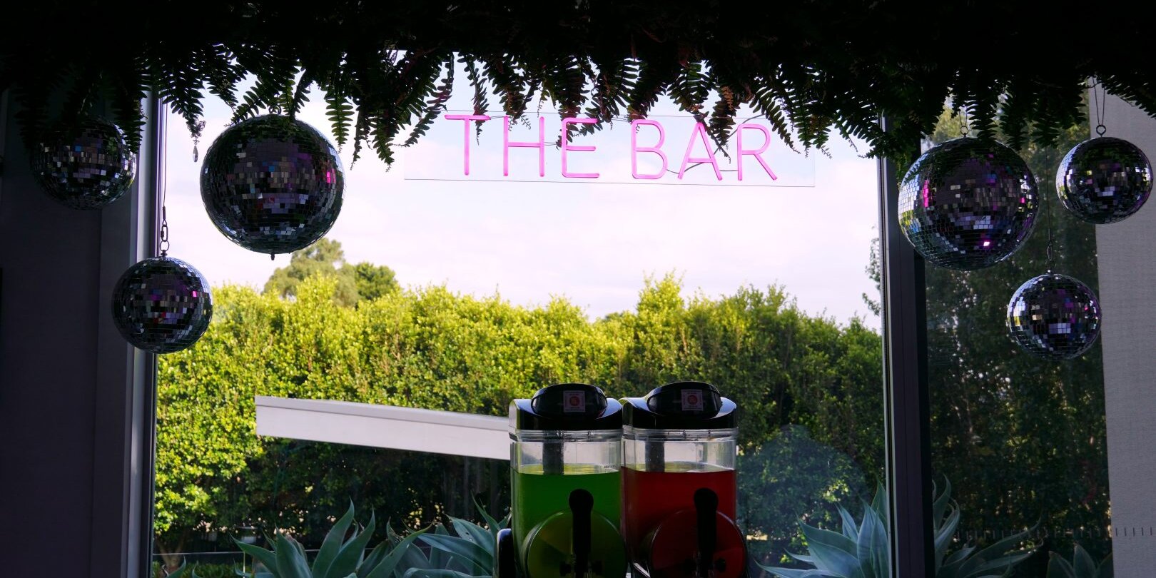 the bar neon sign, mirror balls, cocktail machine, greenery