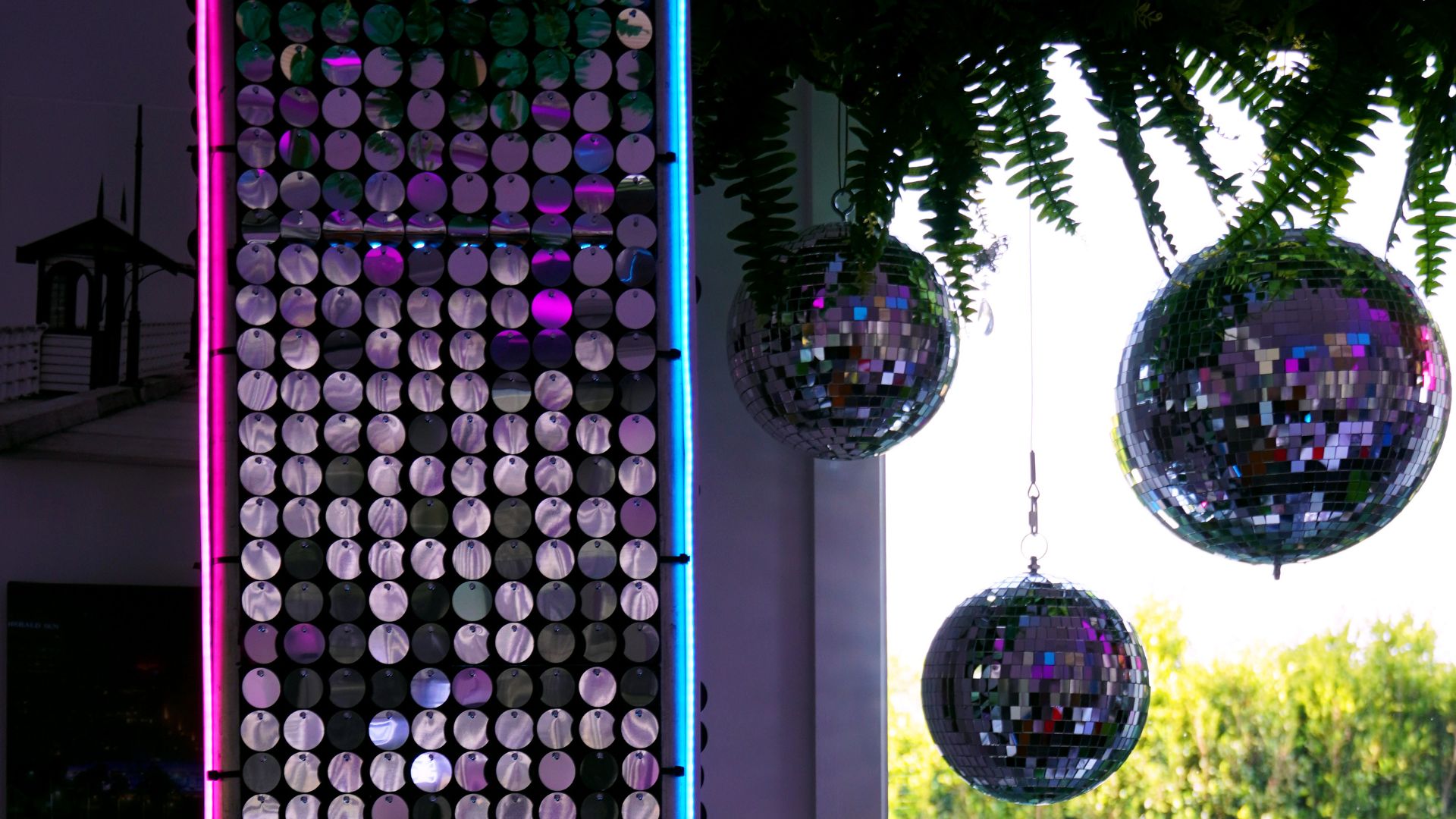 silver sequin panels, mirror balls, neon strips, greenery