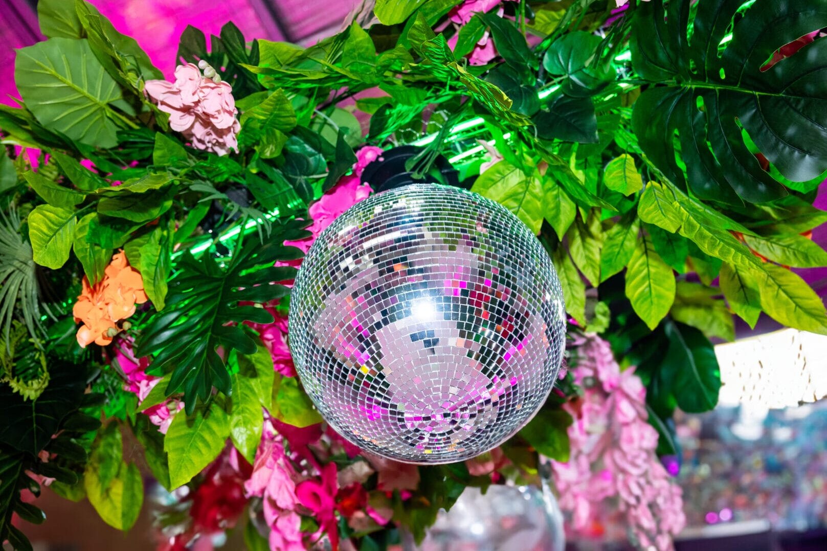 Silver mirror ball surrounded by tropical greenery and flowers