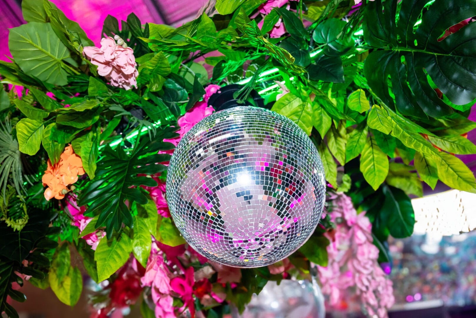 Silver mirror ball surrounded by tropical greenery and flowers
