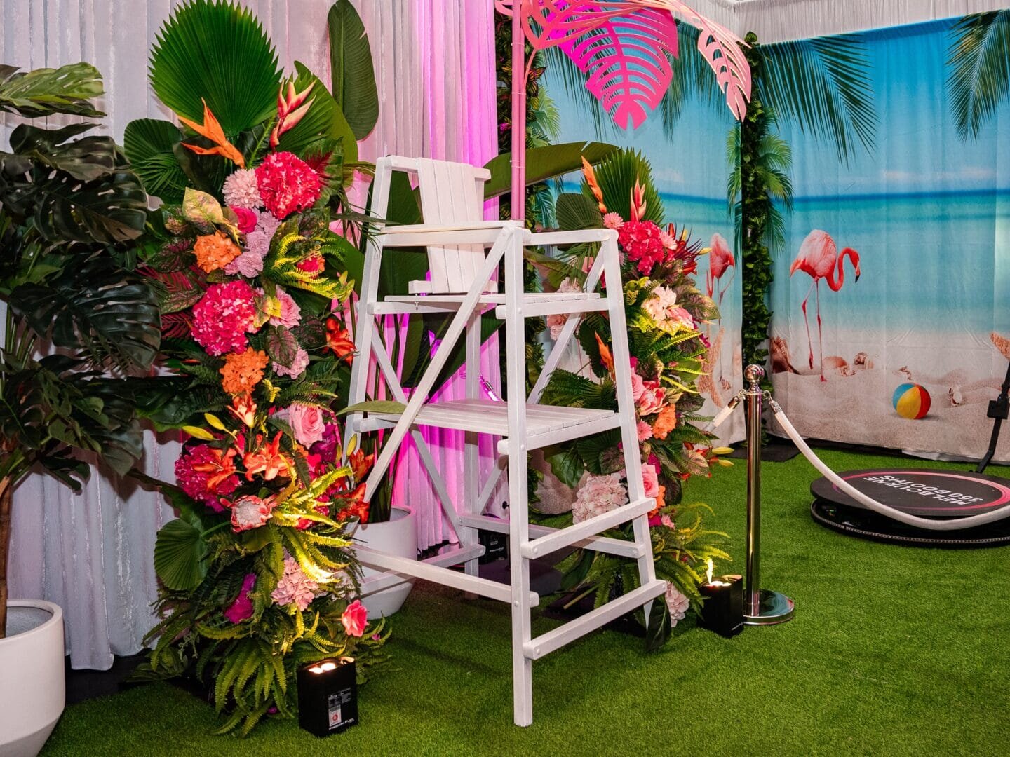 White lifeguard chair with tropical floral and greenery installations on either side
