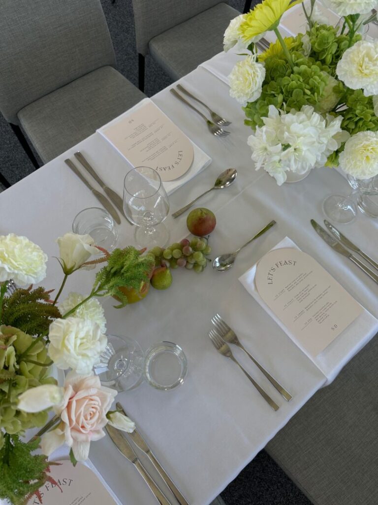 Wedding reception table setup with white linen, contemporary florals Wedding Decorating Trends for 2025