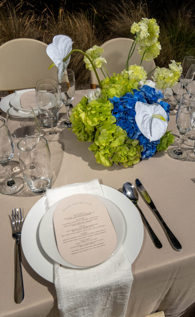 wedding reception table setting with stationary, bright florals
