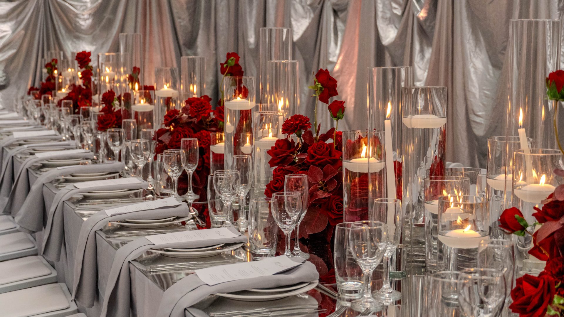 Red & Silver Dinner Party setup featuring red florals, candles, silver drape, and silver acrylic 7 things to work out before planning a party