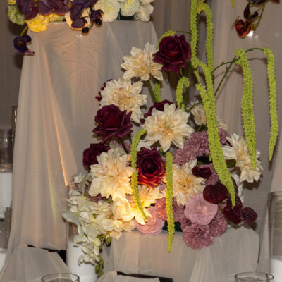 Moody florals with draped plinths Moody florals on plinth with beige drape and candles