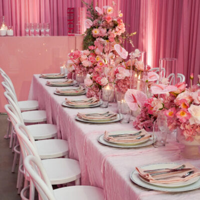 Pink Party Styling featuring a long tablescape with abundant pink florals, candlelight and soft draping.